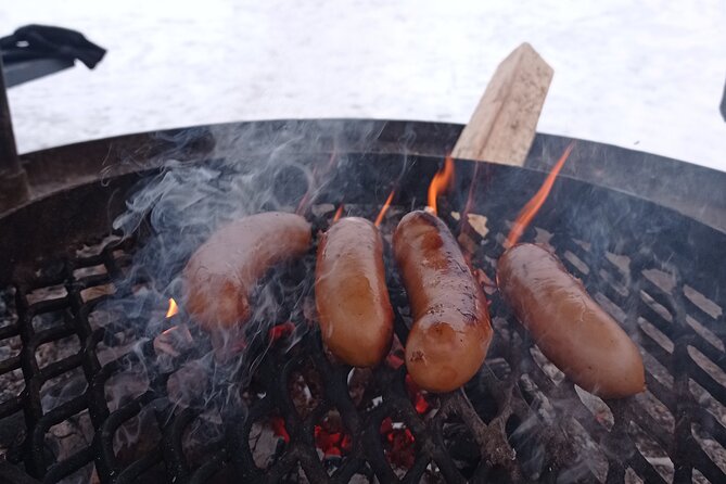 Ice fishing experience with Backpacker Helsinki Tour - The fireside finale: grilled sausages, glögi, and piparri