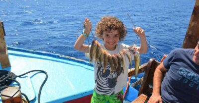 Rhodes Town: Fishing Boat Trip with Fish Meal and Swim Stops - Getting on board at Mandraki Harbor (and settling in fast)
