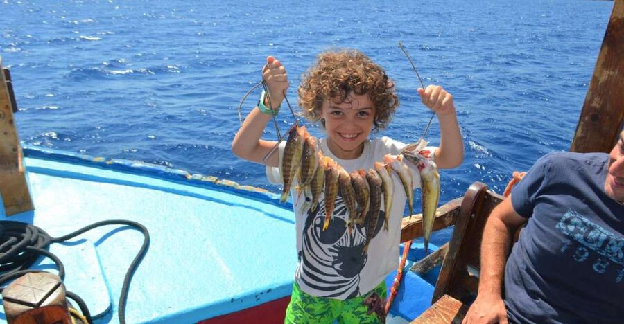 Rhodes Town: Fishing Boat Trip with Fish Meal and Swim Stops - Getting on board at Mandraki Harbor (and settling in fast)